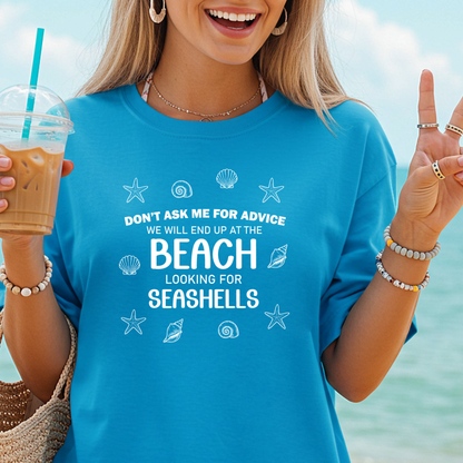 Woman wearing a blue t-shirt with beach-themed text and graphics, holding a drink with a straw.