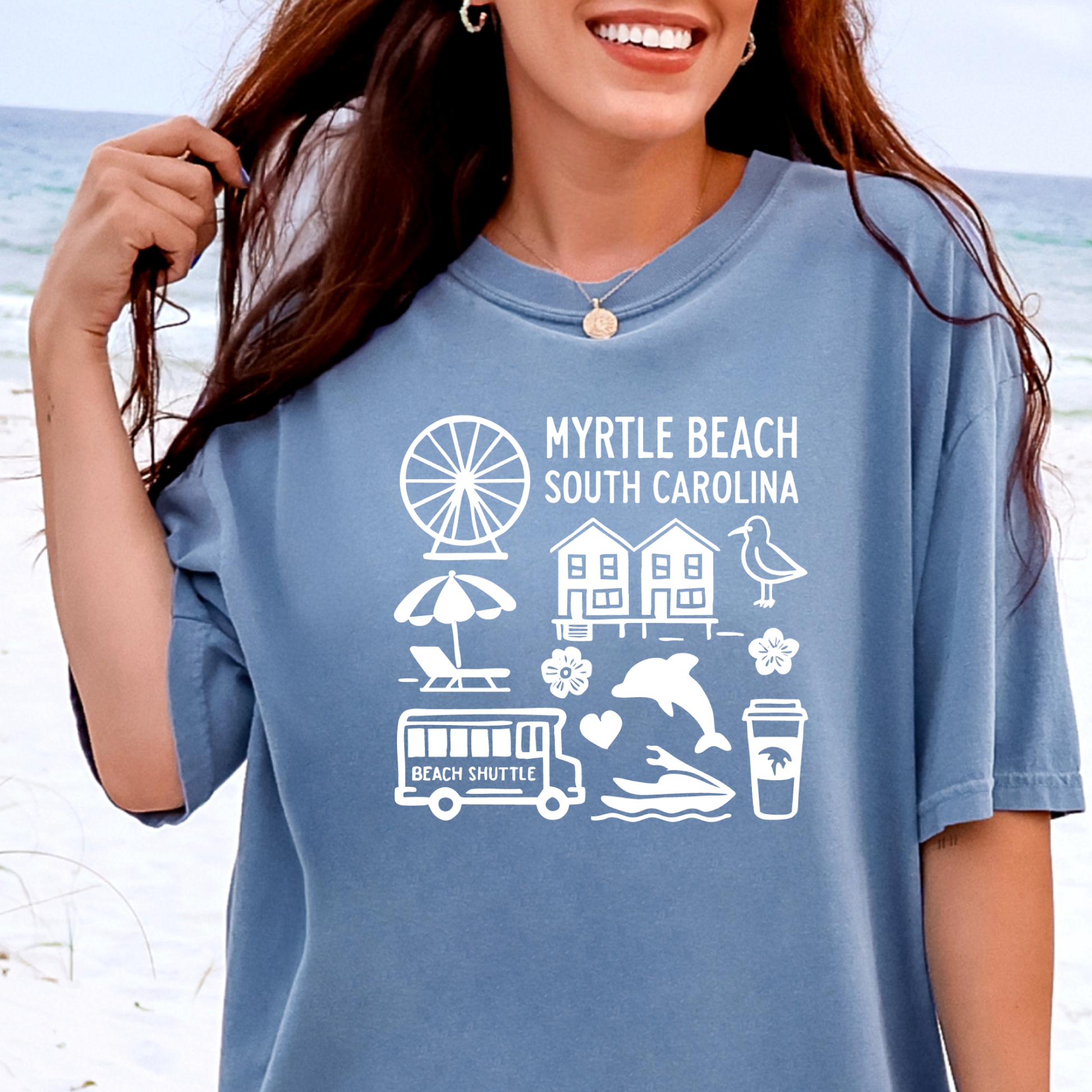 Person wearing a blue t-shirt with 'Myrtle Beach South Carolina' graphics on a beach background