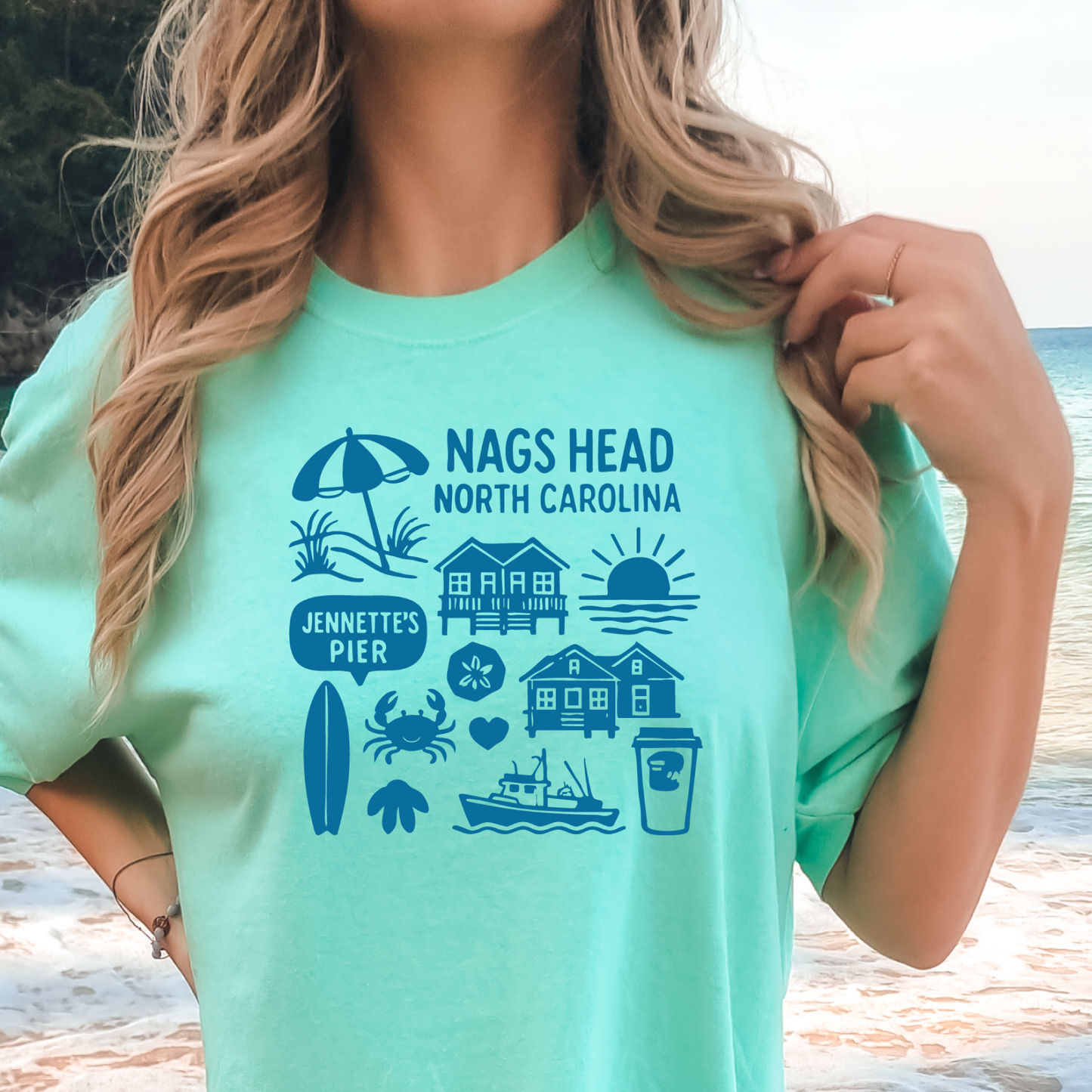 Person wearing a green t-shirt with Nags Head, North Carolina graphics.