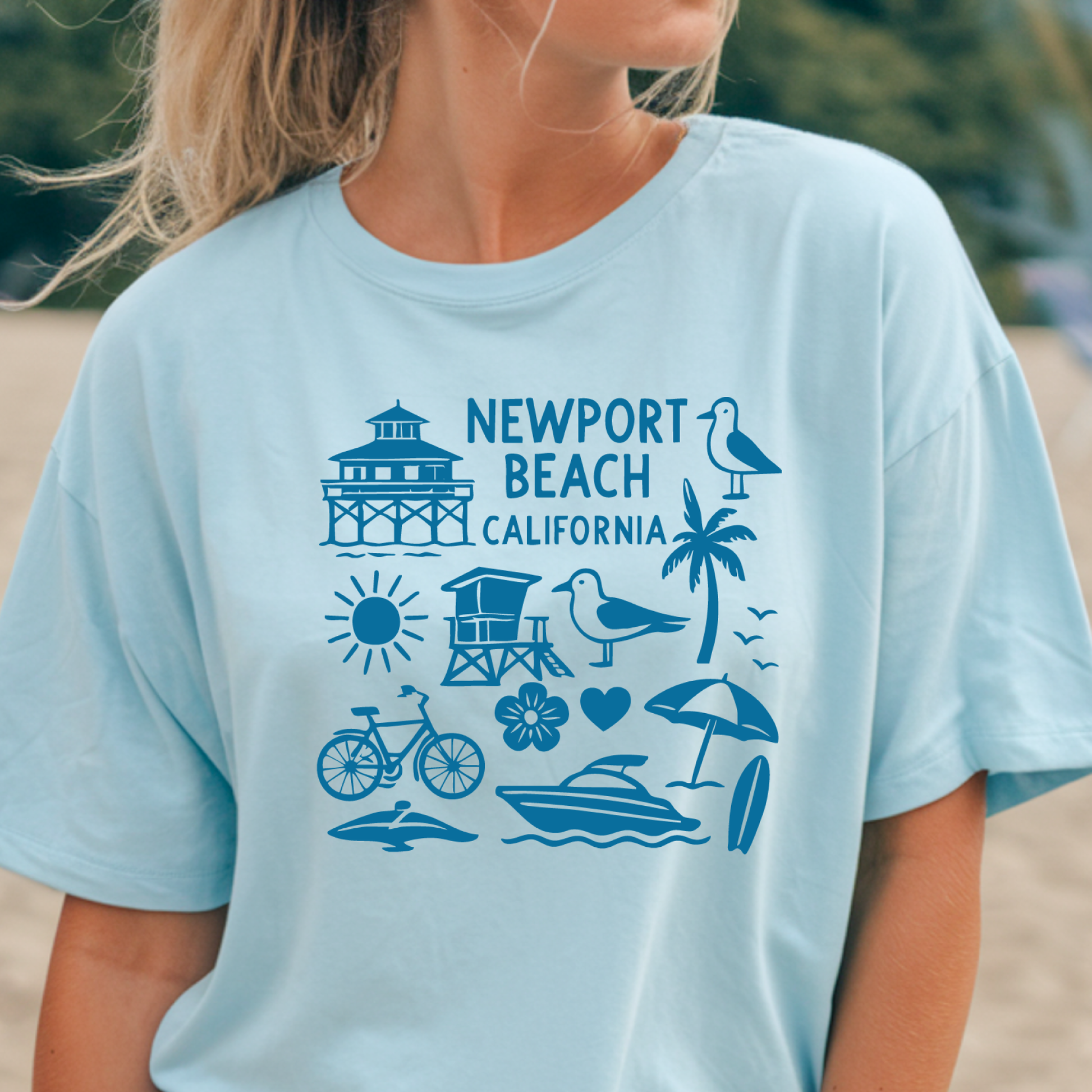 Person wearing a light blue t-shirt with Newport Beach California graphics.