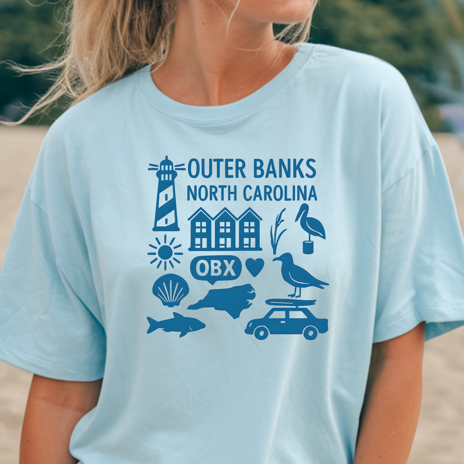 Light blue t-shirt with Outer Banks, North Carolina graphics worn by a person.