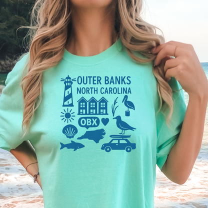 Person wearing a green t-shirt with Outer Banks, North Carolina graphics on a beach.