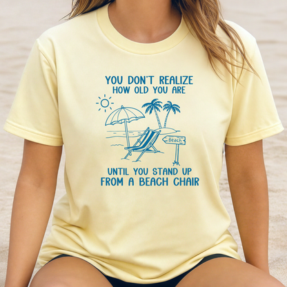Person wearing a yellow t-shirt with a beach-themed design and text.