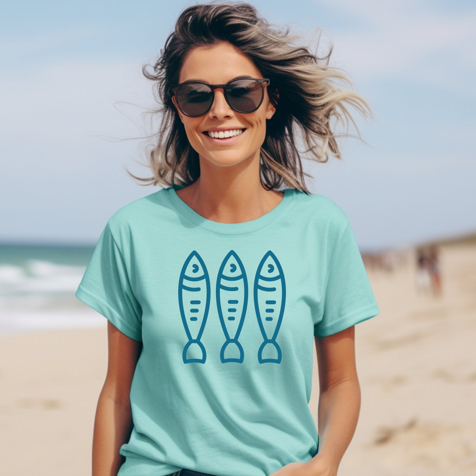 Comfort Colors 1717 Fisherman's Aesthetic t shirt with three sardines in a  one color graphic. Picture of a girl on the beach in a t shirt.