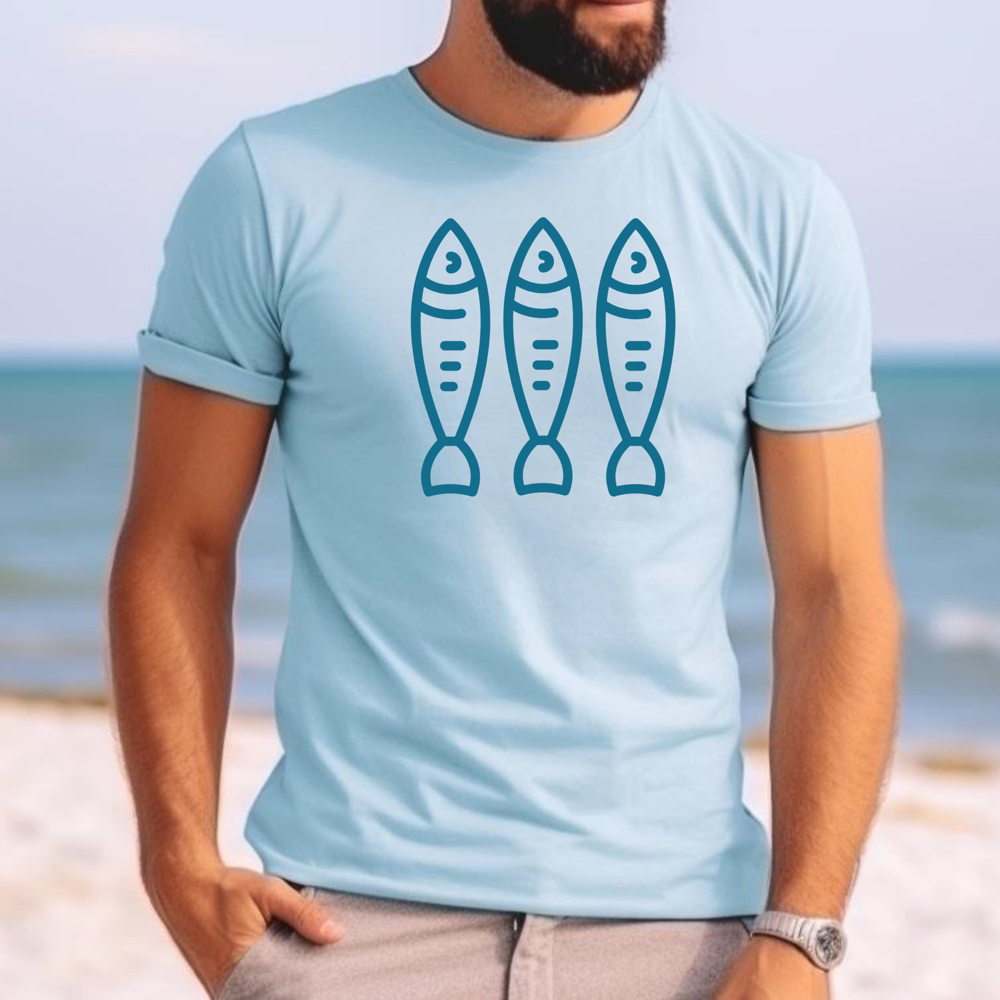 Comfort Colors 1717 Fisherman's Aesthetic t shirt with three sardines in a  one color graphic. Picture of a man on the beach in a t shirt.