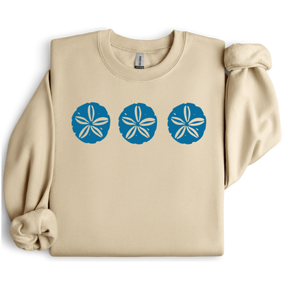Gildan sweatshirt featuring three blue sand dollar graphics printed across the chest. Soft cotton-poly blend fabric with ribbed cuffs and waistband for a cozy, durable fit. Perfect for beach lovers and coastal style enthusiasts who appreciate simple ocean-inspired designs. Ideal for layering on cool seaside evenings or adding a subtle beach vibe to casual outfits.