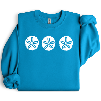 Gildan sweatshirt featuring three blue sand dollar graphics printed across the chest. Soft cotton-poly blend fabric with ribbed cuffs and waistband for a cozy, durable fit. Perfect for beach lovers and coastal style enthusiasts who appreciate simple ocean-inspired designs. Ideal for layering on cool seaside evenings or adding a subtle beach vibe to casual outfits.