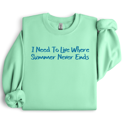 Gildan sweatshirt featuring blue text that reads “I Need To Live Where Summer Never Ends.” Cozy beach-inspired pullover for those who love the sun and ocean lifestyle. Made with a soft cotton-poly blend, ribbed cuffs, and double-needle stitching for durability. Perfect for coastal adventures, vacations, or casual summer-style outfits. Ideal gift for beach lovers and anyone who wishes for endless summer days.