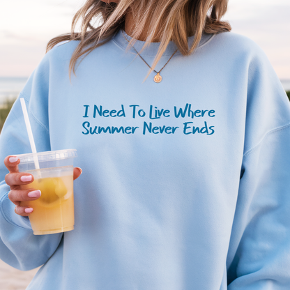 Gildan sweatshirt featuring blue text that reads “I Need To Live Where Summer Never Ends.” Cozy beach-inspired pullover for those who love the sun and ocean lifestyle. Made with a soft cotton-poly blend, ribbed cuffs, and double-needle stitching for durability. Perfect for coastal adventures, vacations, or casual summer-style outfits. Ideal gift for beach lovers and anyone who wishes for endless summer days.