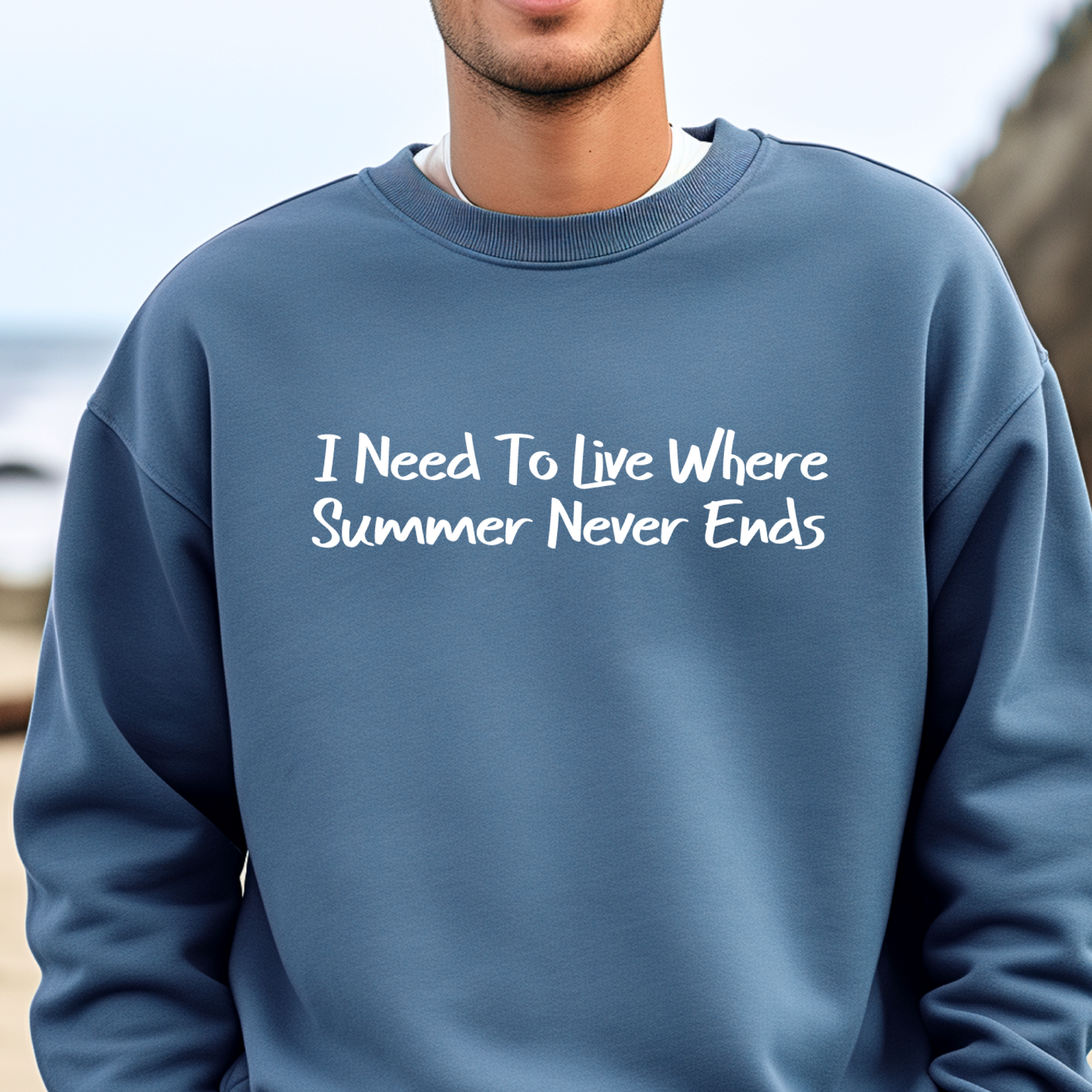 Gildan sweatshirt featuring blue text that reads “I Need To Live Where Summer Never Ends.” Cozy beach-inspired pullover for those who love the sun and ocean lifestyle. Made with a soft cotton-poly blend, ribbed cuffs, and double-needle stitching for durability. Perfect for coastal adventures, vacations, or casual summer-style outfits. Ideal gift for beach lovers and anyone who wishes for endless summer days.
