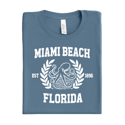 Folded steel blue t-shirt with 'Miami Beach Florida' text and octopus design on a white background