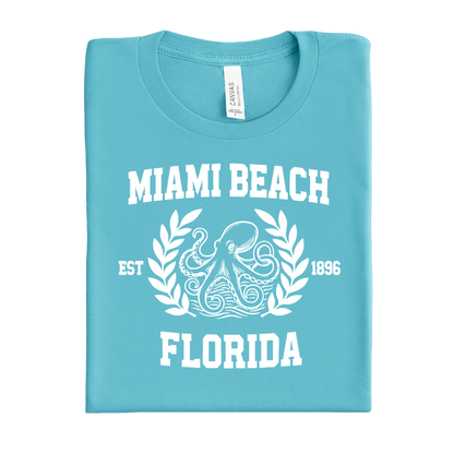 Folded turquoise  t-shirt with 'Miami Beach, Florida' text and octopus design on a white background