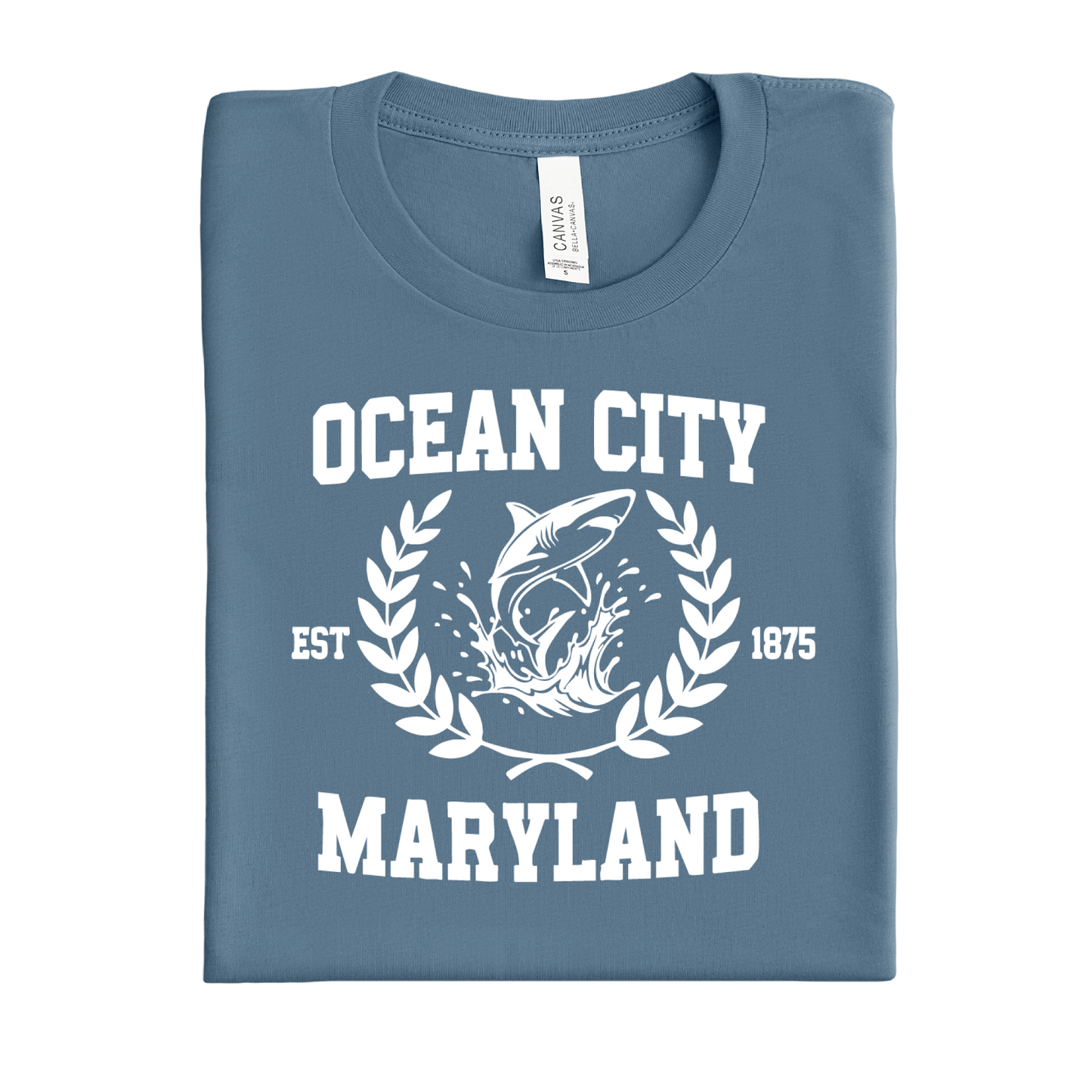 Folded steel blue t-shirt with 'Ocean City, Maryland' text and shark graphic on a white background