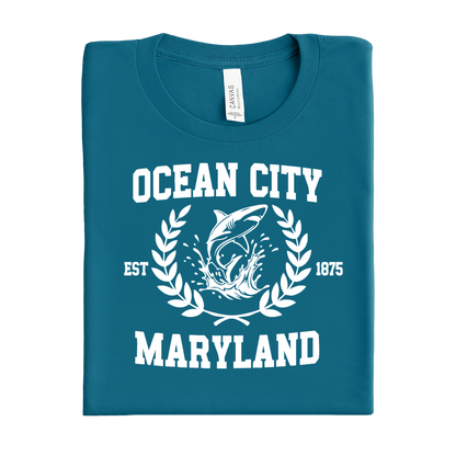 Folded deep teal t-shirt with 'Ocean City, Maryland' text and shark graphic on a white background