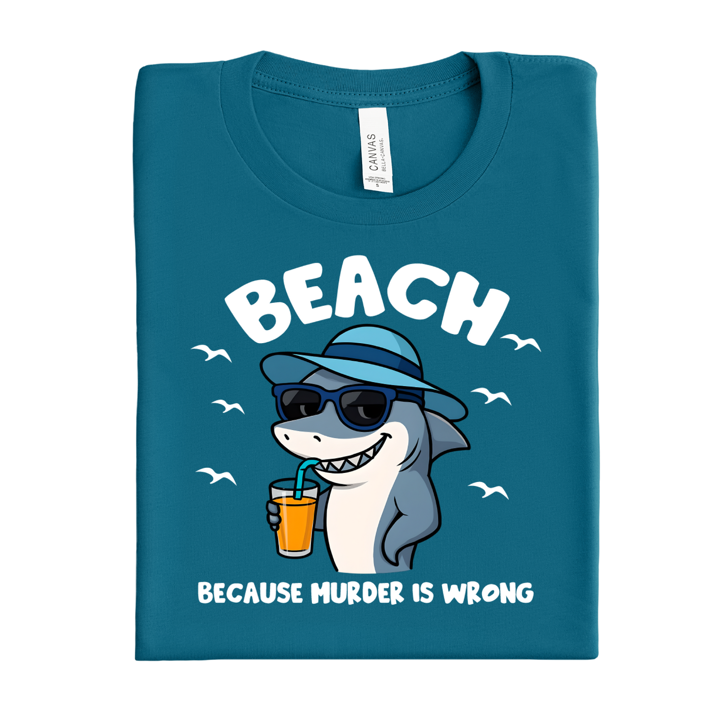 Folded deep teal t-shirt with a shark graphic and text on a white background