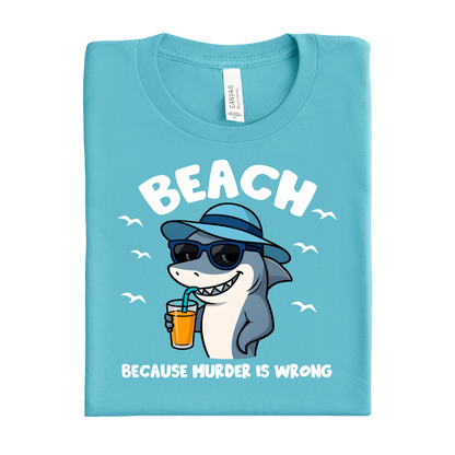 Folded turquoise t-shirt with a shark graphic and text on a white background