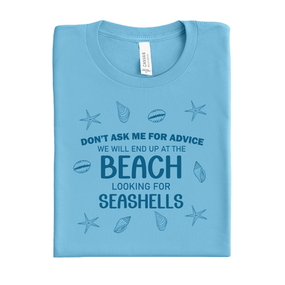 Folded ocean blue t-shirt with beach-themed text and graphics on a white background