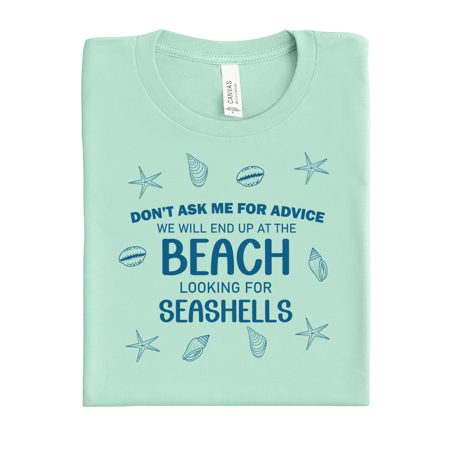Folded mint green t-shirt with beach-themed text and graphics on a white background