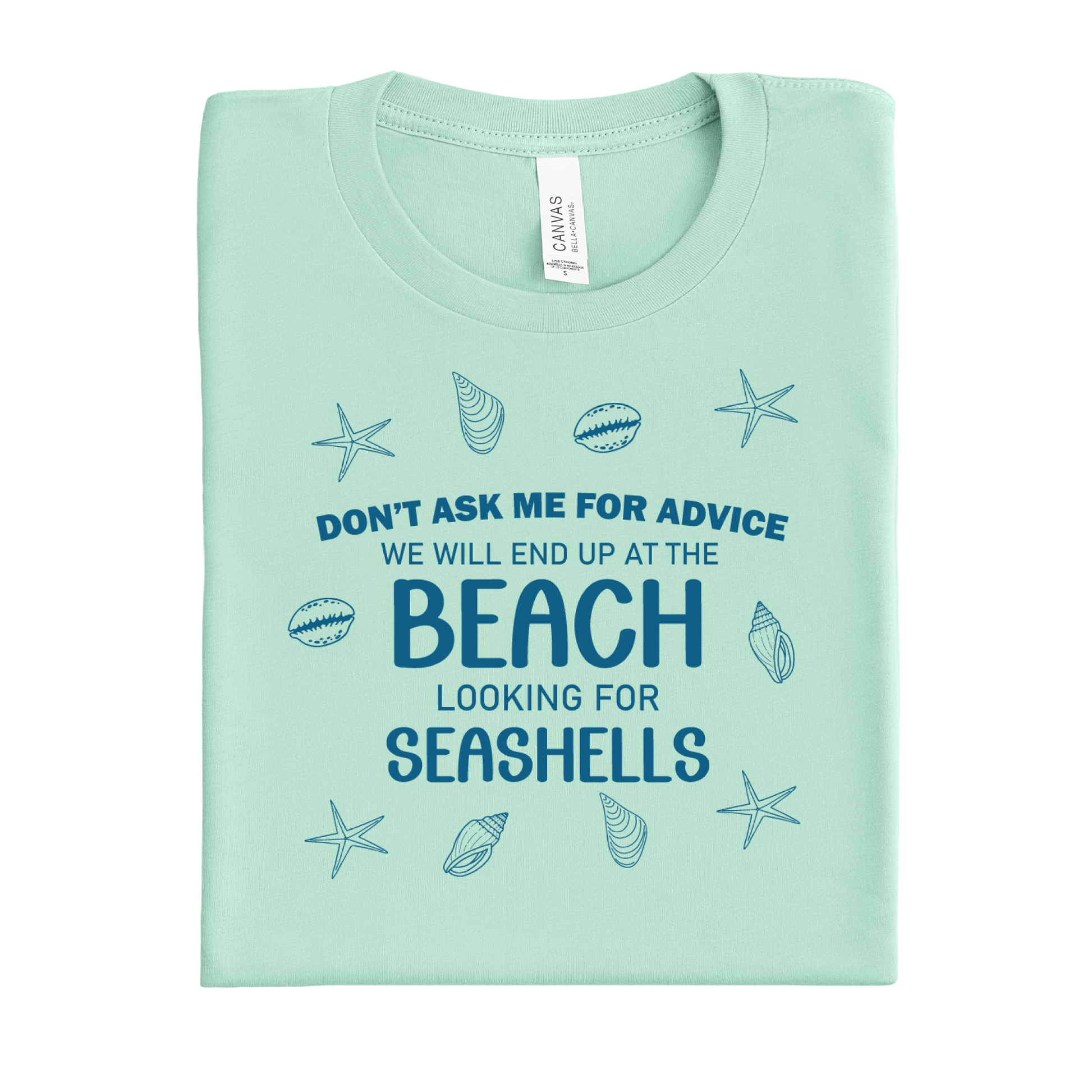 Folded mint green t-shirt with beach-themed text and graphics on a white background