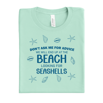 Folded mint green t-shirt with beach-themed text and graphics on a white background