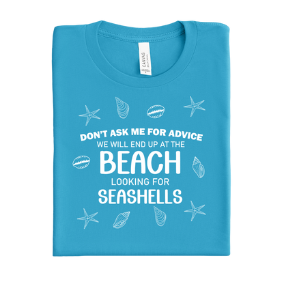 Folded aqua blue t-shirt with beach-themed text and graphics on a white background