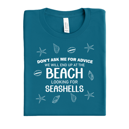 Folded deep teal t-shirt with beach-themed text and graphics on a white background