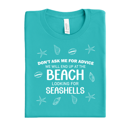 Folded teal t-shirt with beach-themed text and graphics on a white background