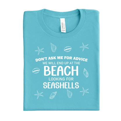 Folded turquoise t-shirt with beach-themed text and graphics on a white background