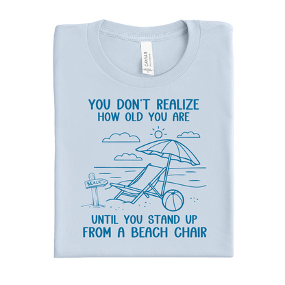 Light blue t-shirt with beach-themed design and text on a white background