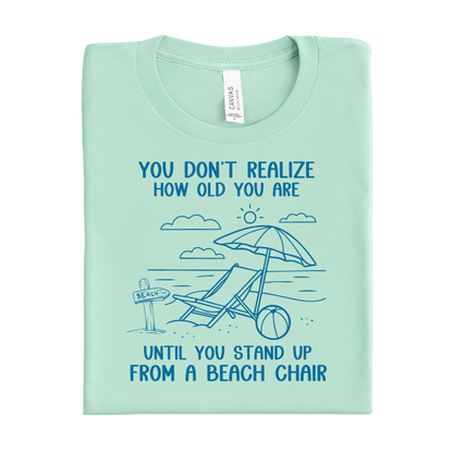 Mint green t-shirt with beach graphic and text on a white background