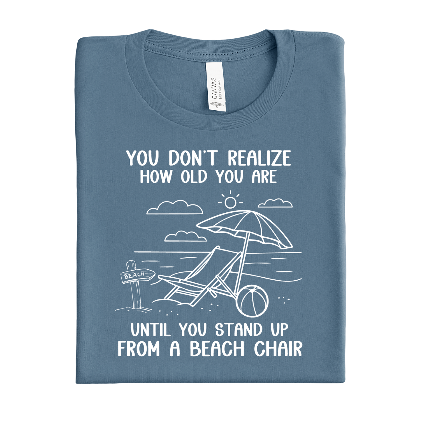 Folded blue steel t-shirt with beach graphic and text on a white background