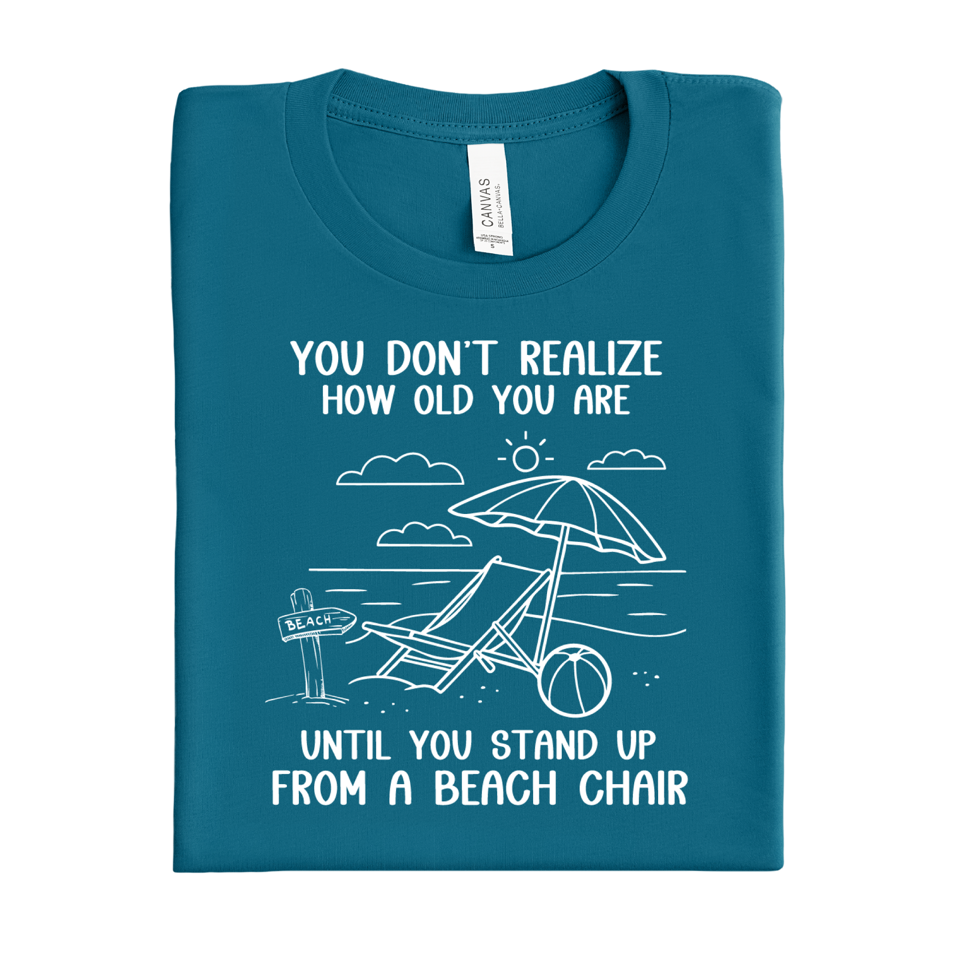 Folded deep teal t-shirt with beach-themed graphic and text on a white background
