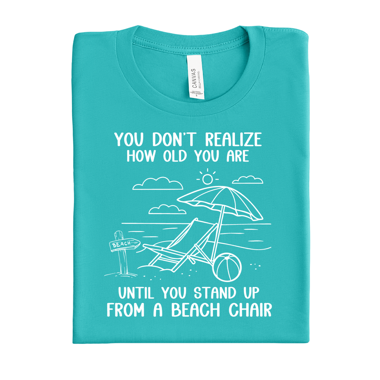 Folded teal t-shirt with beach-themed design and text on a white background