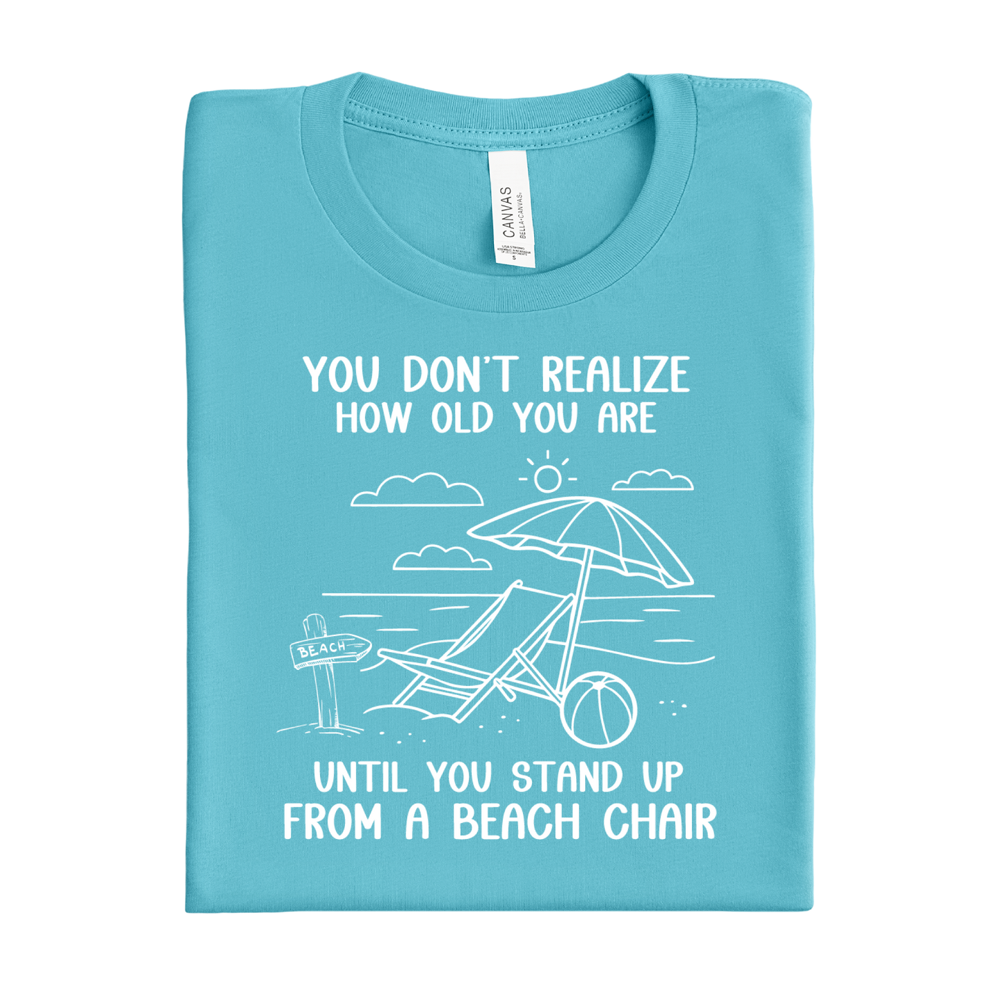 Folded turquoise t-shirt with beach graphic and text on a white background