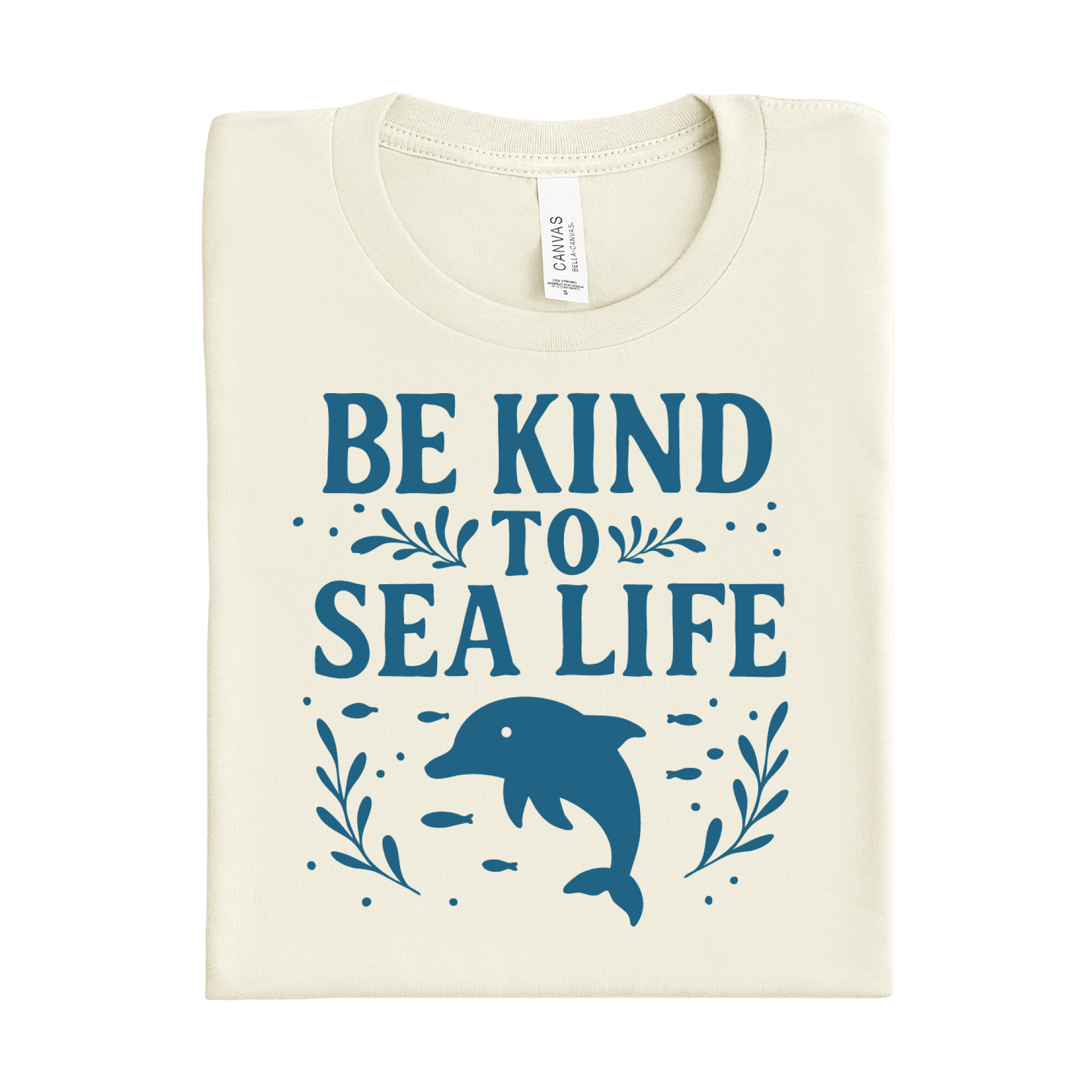 Folded t-shirt with 'Be Kind to Sea Life' text and dolphin graphic on a white background
