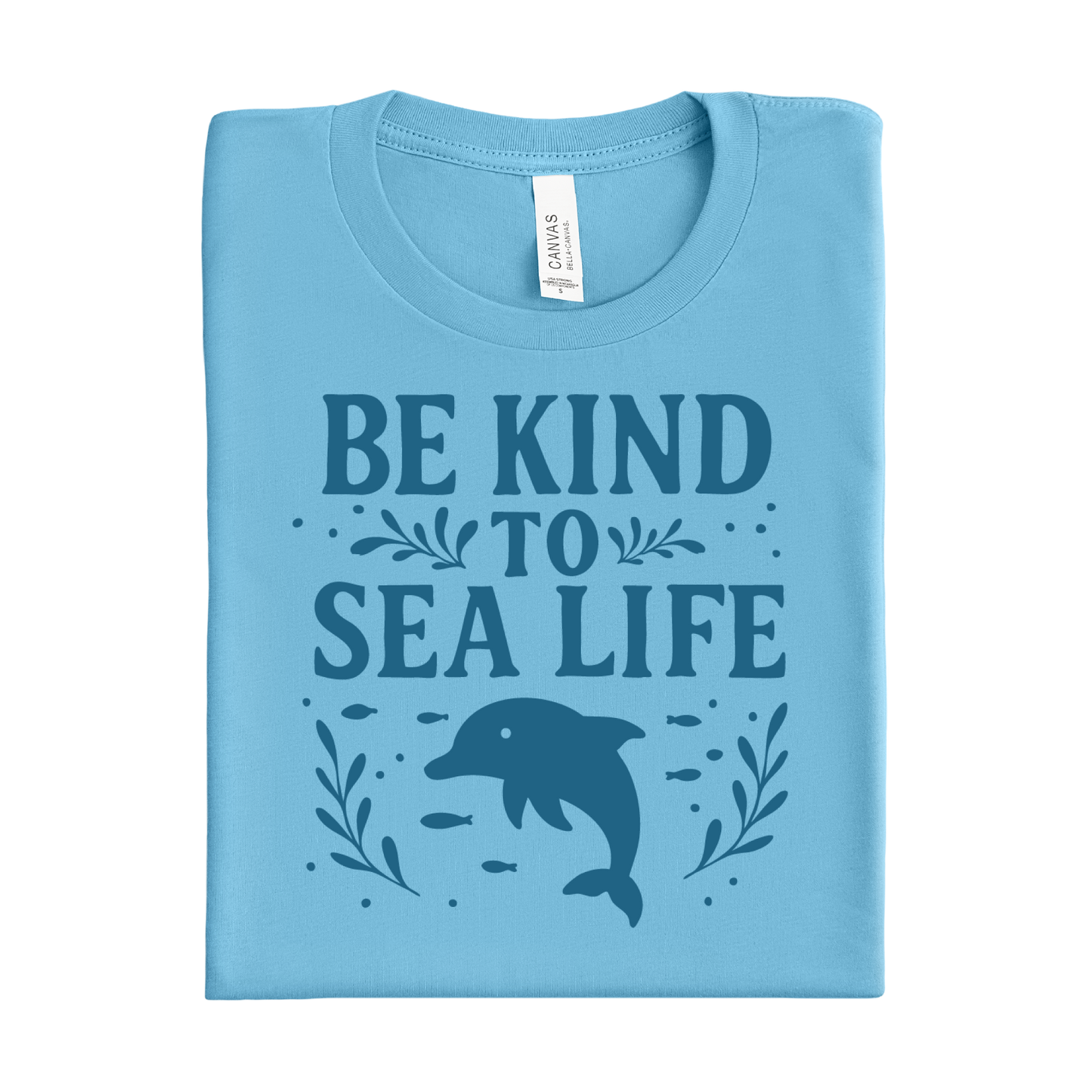 Folded ocean blue t-shirt with 'Be Kind to Sea Life' text and dolphin graphic on a white background
