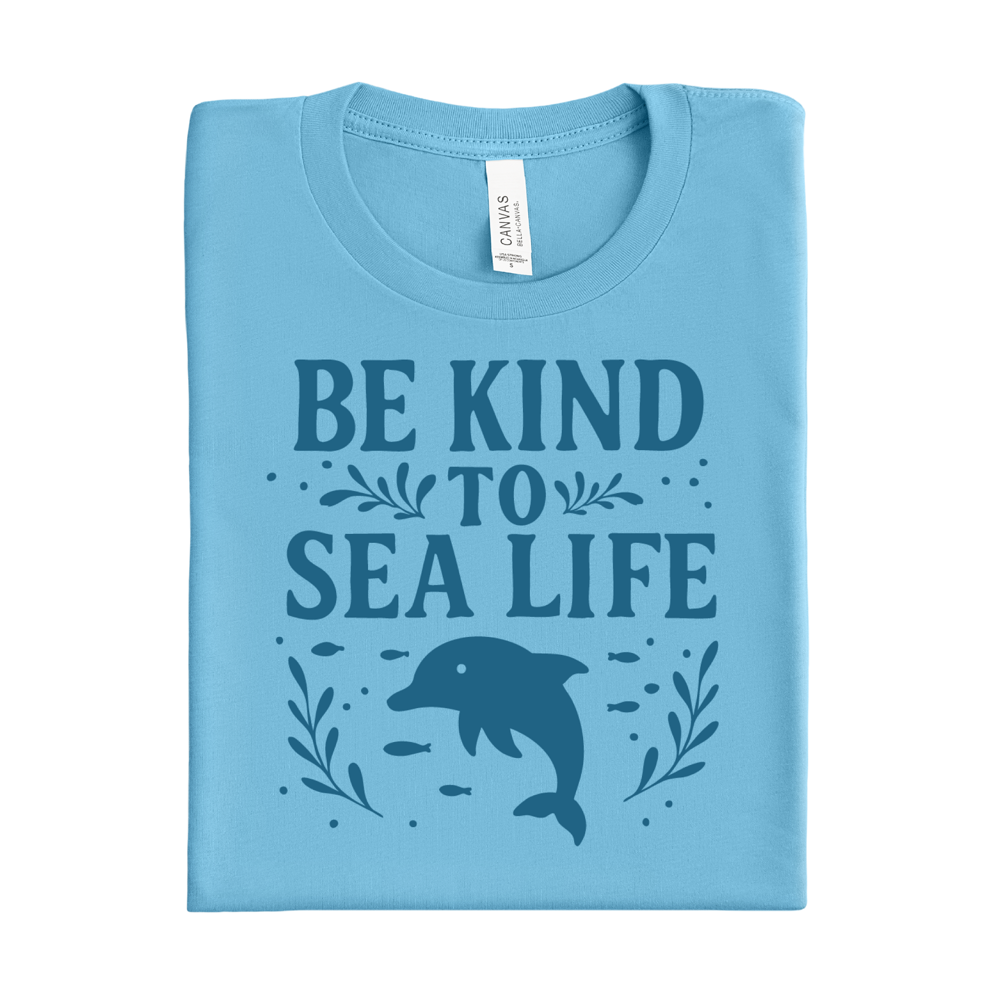 Folded ocean blue t-shirt with 'Be Kind to Sea Life' text and dolphin graphic on a white background