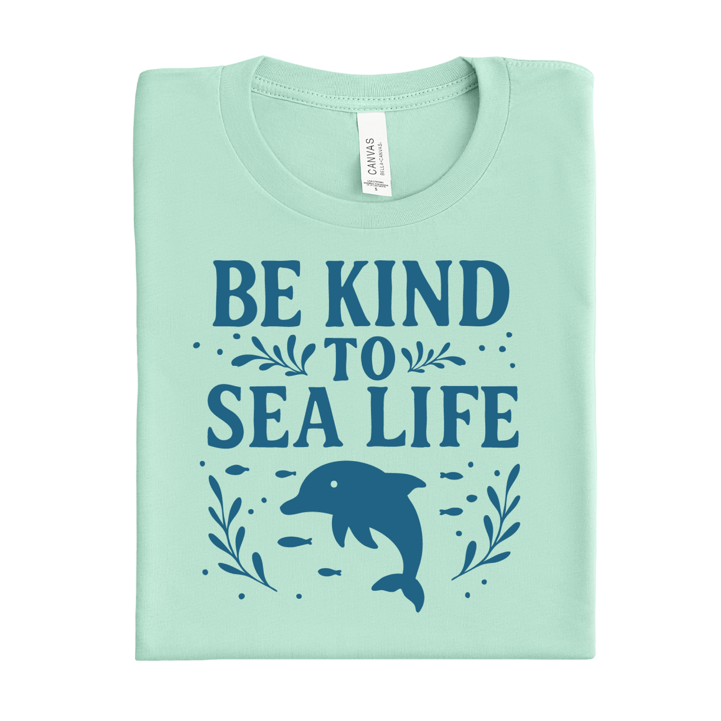 Mint green t-shirt with 'Be Kind to Sea Life' text and dolphin graphic on a white background