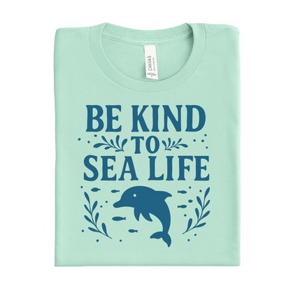 Mint green t-shirt with 'Be Kind to Sea Life' text and dolphin graphic on a white background