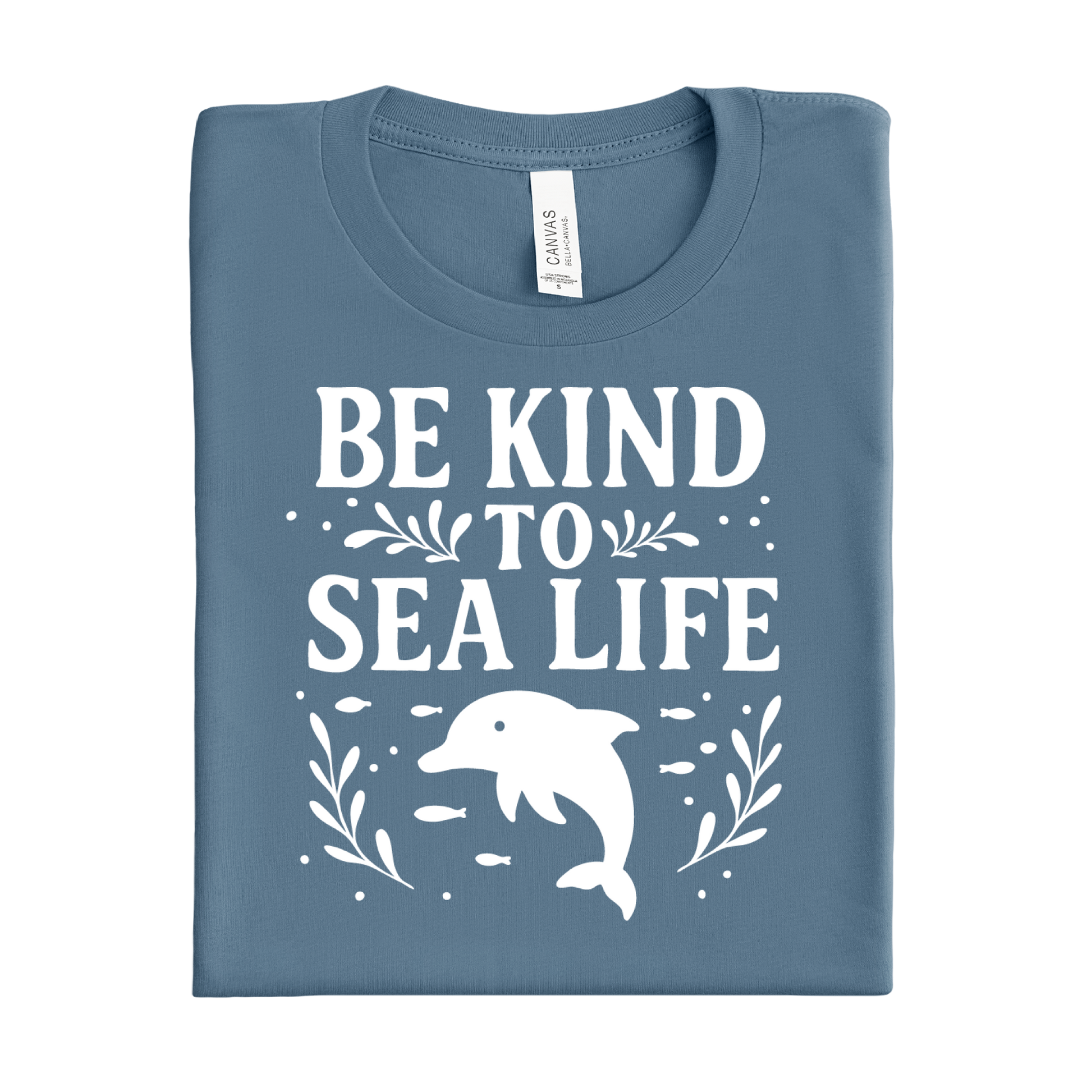 Folded steel blue t-shirt with 'Be Kind to Sea Life' text and dolphin graphic on a white background