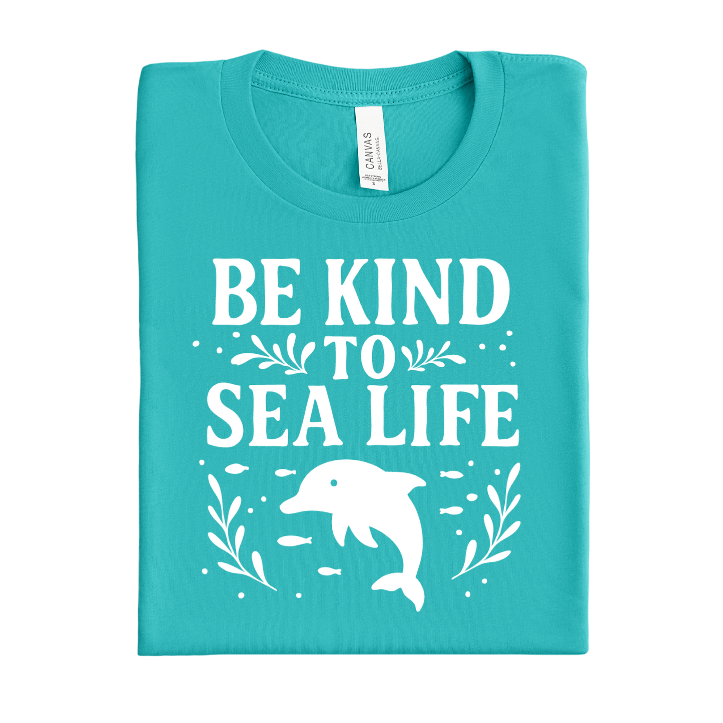 Folded teal t-shirt with 'Be Kind to Sea Life' text and dolphin graphic on a white background