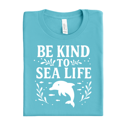 Folded turquoise t-shirt with 'Be Kind to Sea Life' text and dolphin graphic on a white background