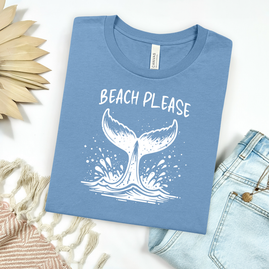 Bella Canvas 3001 "Beach Please" t shirt with a Whale Tail splashing in the water in one color graphic. Picture on a flay lay mockup with pair of blue jeans and blanket and a wicker sun shaped accessory.