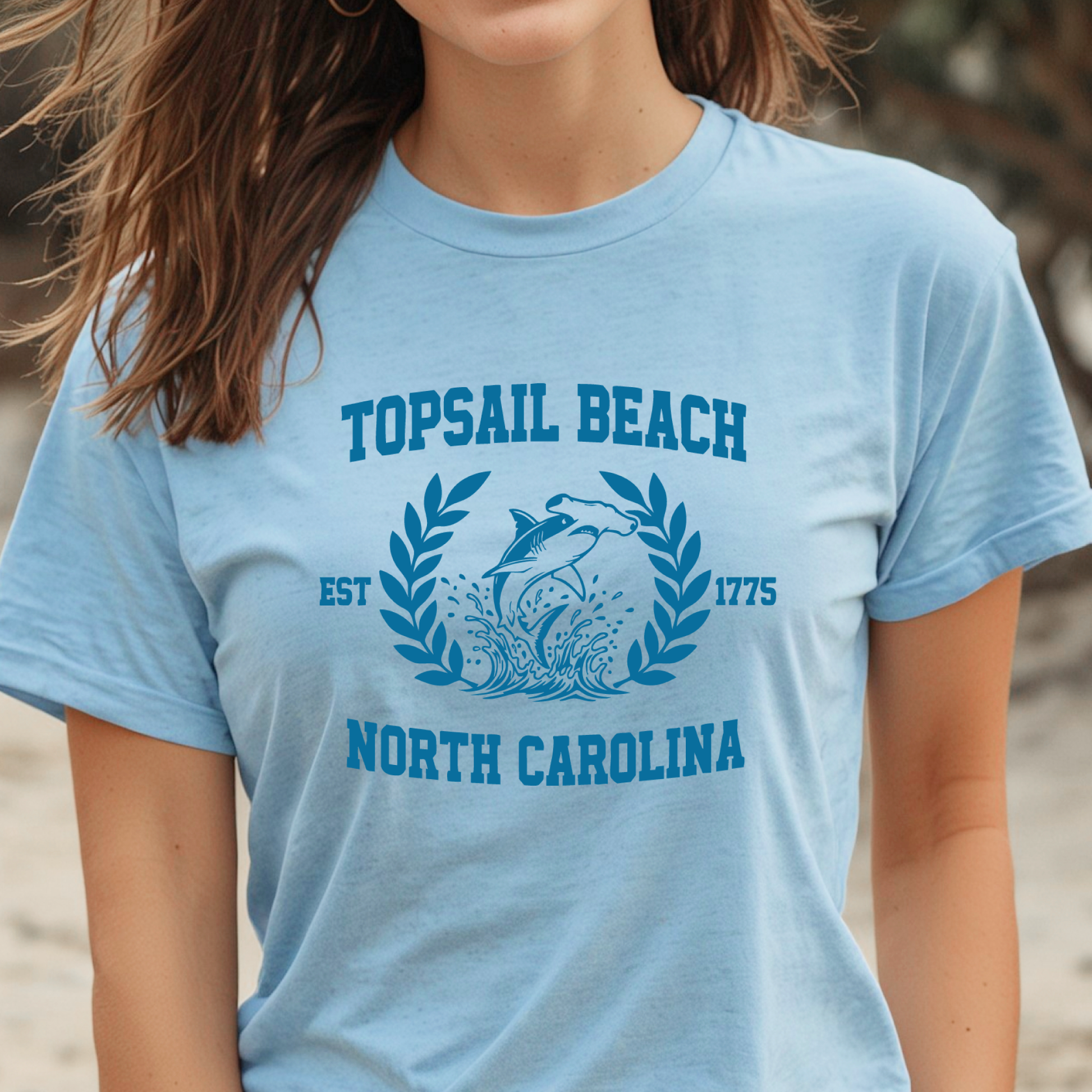 Person wearing a light blue t-shirt with 'Topsail Beach, North Carolina' design.