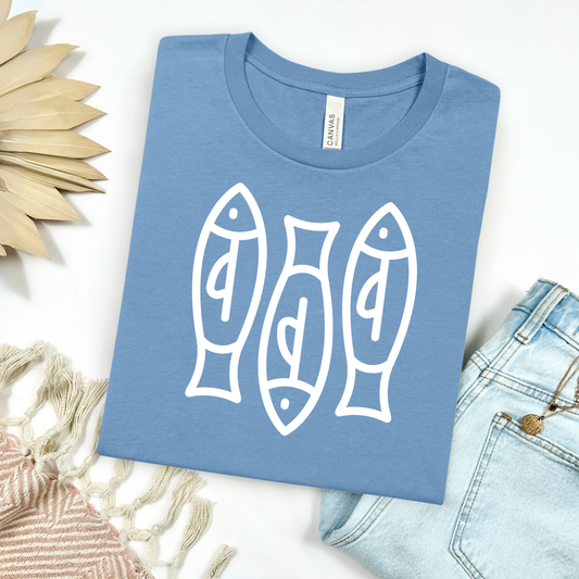 Bella canvas t shirt of a monoline art of  three sardines in one color graphic. Picture on a flay lay mockup with pair of blue jeans and blanket and a wicker sun shaped accessories.