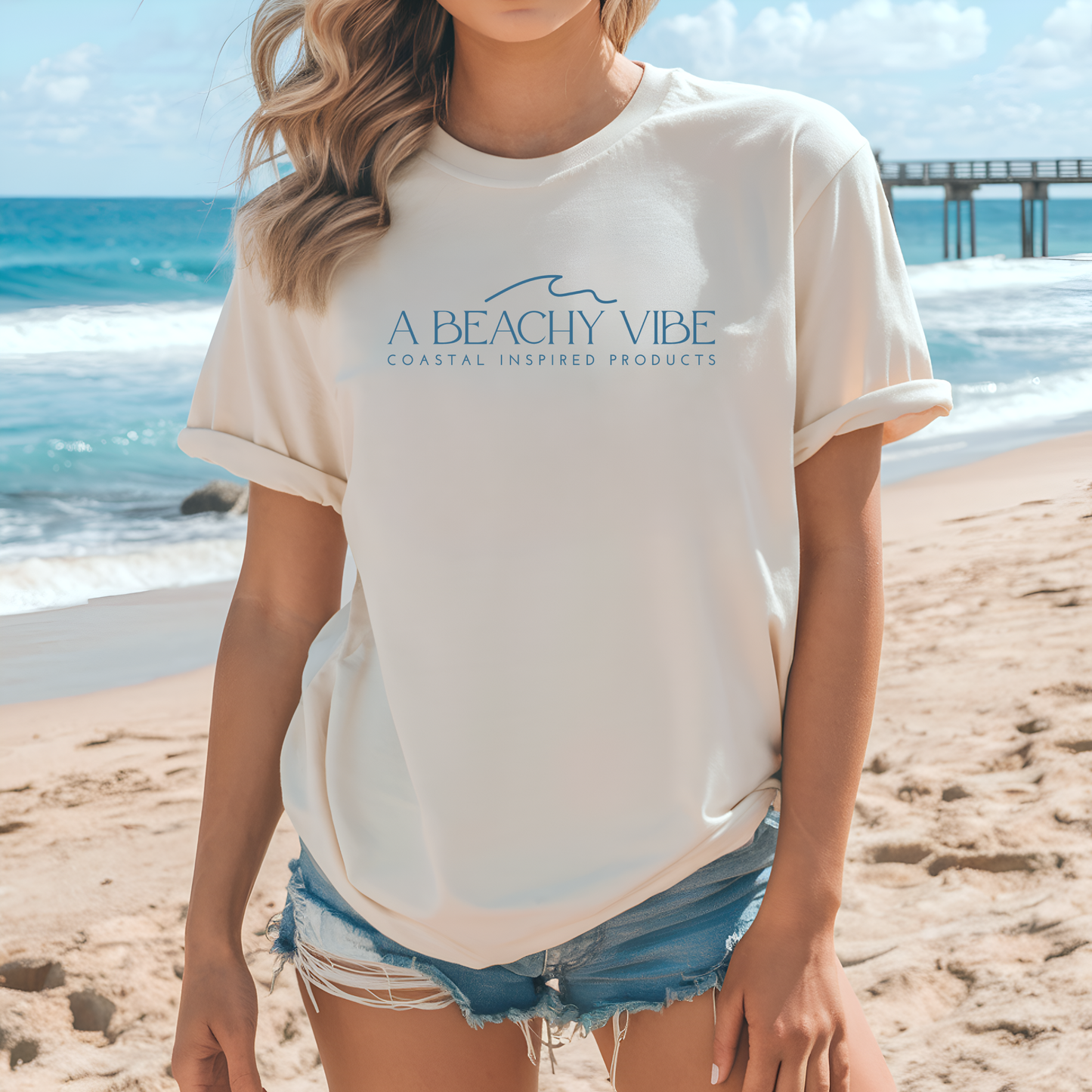 Bella Canvas 3001 "A Beachy Vibe" t shirt with a simple wave graphic with text and one color graphic. Picture of a girl on the beach in a t shirt.
