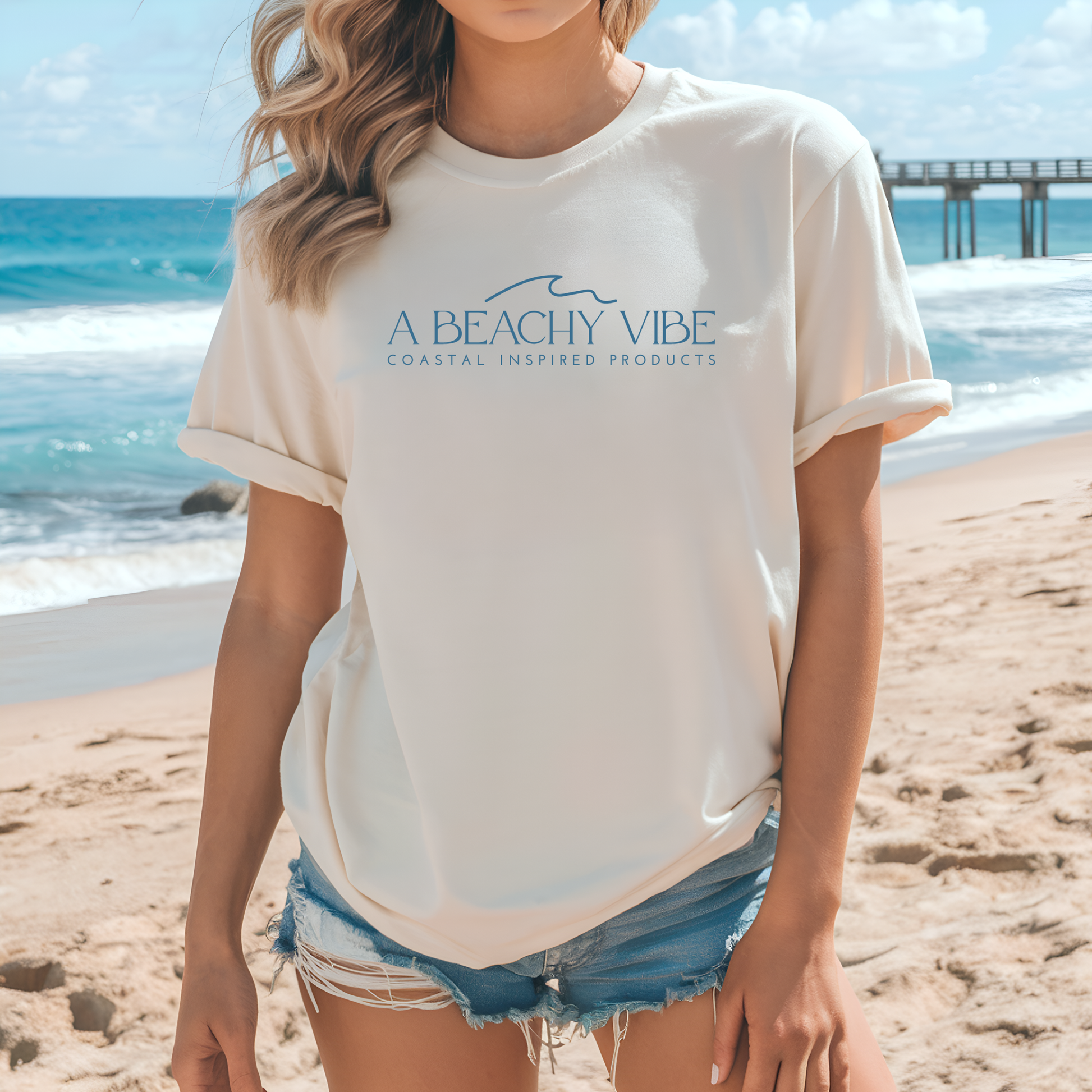 Bella Canvas 3001 "A Beachy Vibe" t shirt with a simple wave graphic with text and one color graphic. Picture of a girl on the beach in a t shirt.