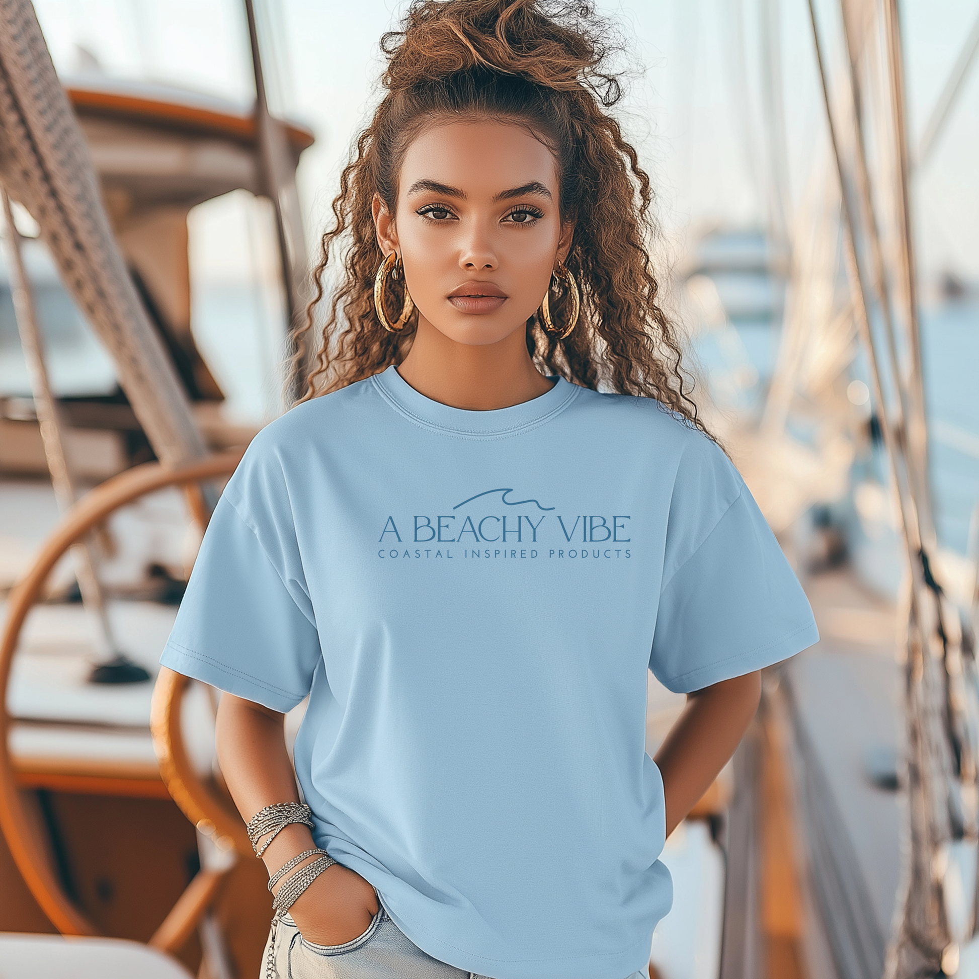 Bella Canvas 3001 "A Beachy Vibe" t shirt with a simple wave graphic with text and one color graphic. Picture of a girl on a boat in a t shirt.