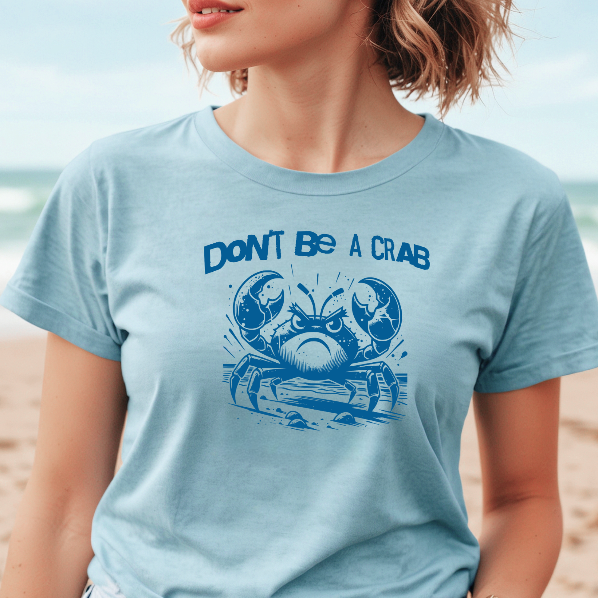 Bella Canvas 3001 "Don't Be A Crab" t shirt with cute angry crab in one color graphic. Picture of a girl standing on the beach wearing a t shirt.