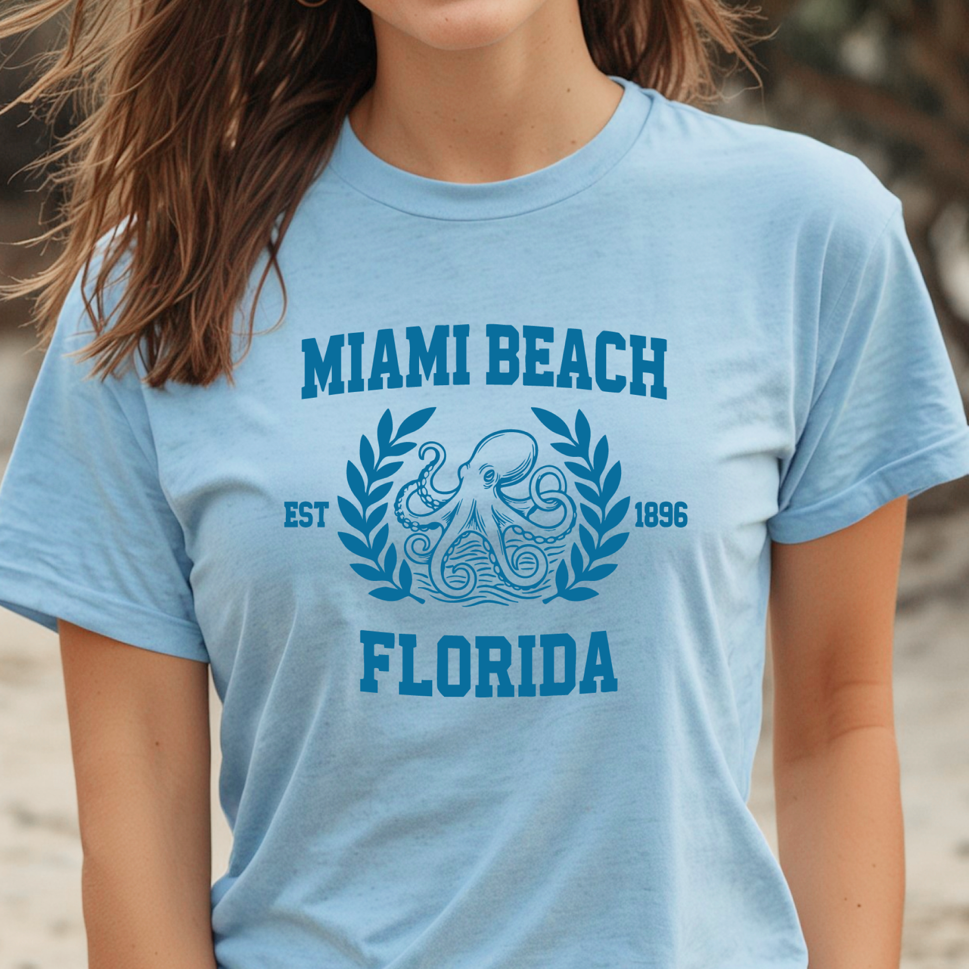 Light blue t-shirt with 'Miami Beach, Florida' design on a beach background